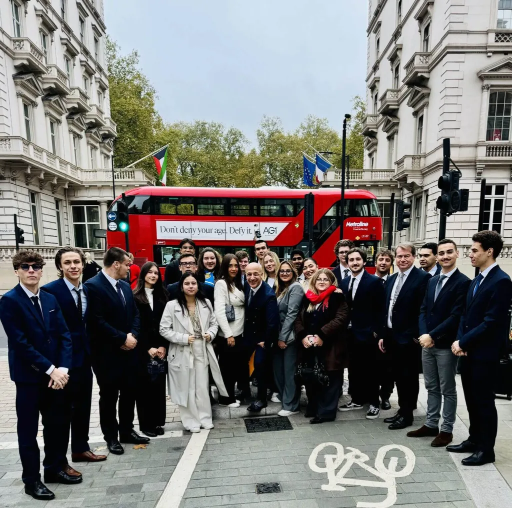 Les étudiants et le Dean, Thierry Sebagh posent devant un bus rouge emblématique de Londres, lors de leur roadtrip IA. 